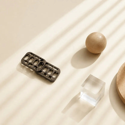 Arca magnetic fidget slider with offset plates beside a wooden sphere and a clear block.