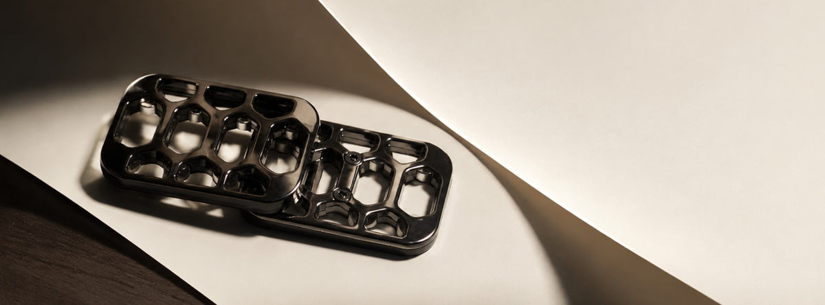 Arca magnetic fidget slider with overlapping open-frame plates on a folded pale display surface.