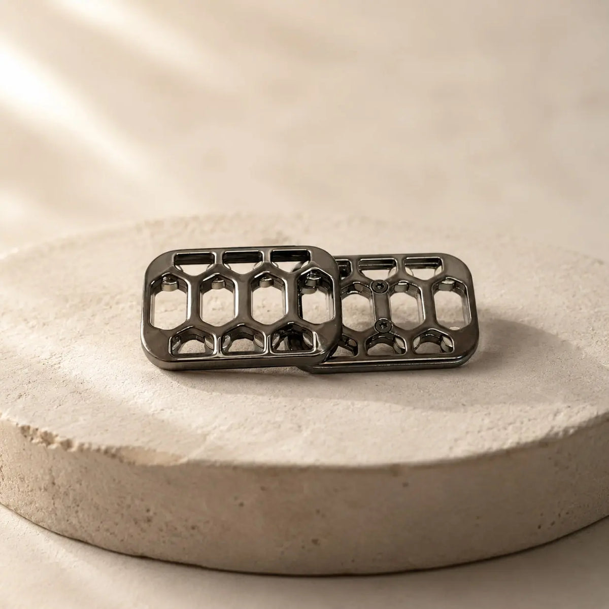 Arca magnetic slider with offset plates resting on a round display stand.