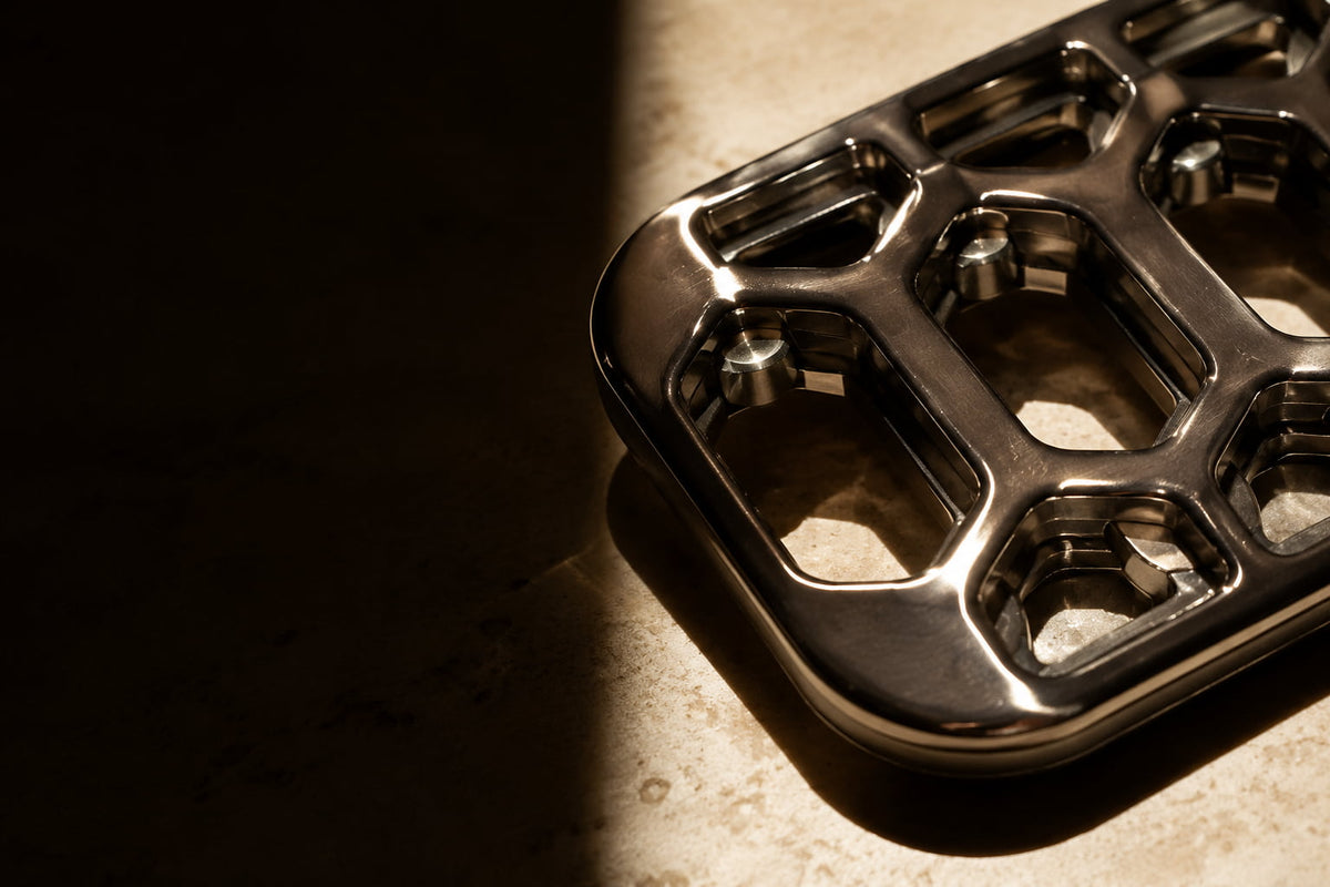 Close-up of an Arca open-frame fidget slider corner, with layered edges in warm light.