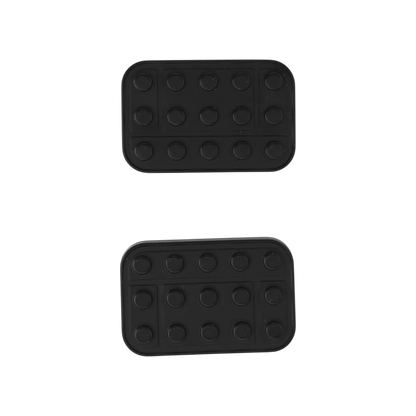 Two separated Brix slider plates showing their dark outer faces with rows of round studs.