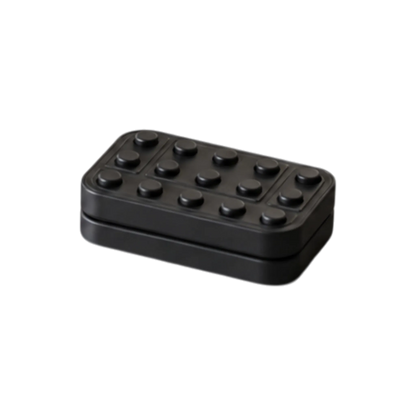 Angled view of the Brix magnetic fidget slider showing its raised studs and the seam between its plates.