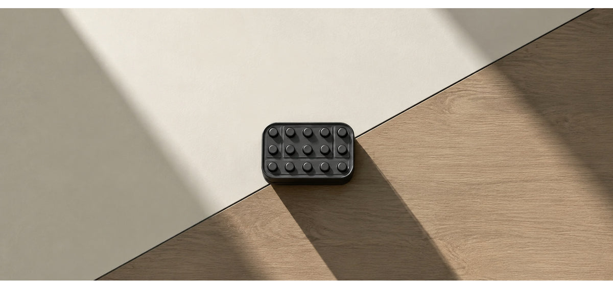 Brix magnetic fidget slider on a surface with wood grain and diagonal shadows.