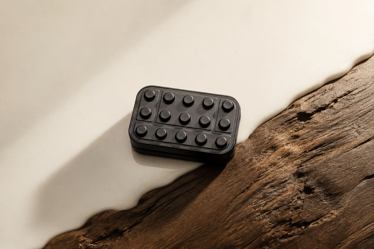 Brix magnetic slider beside a textured wooden edge on a pale surface.