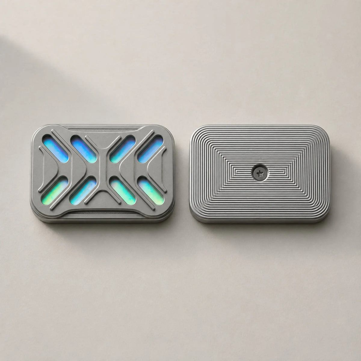 The two Gleam slider plates side by side, showing iridescent cutouts and fine grooves.