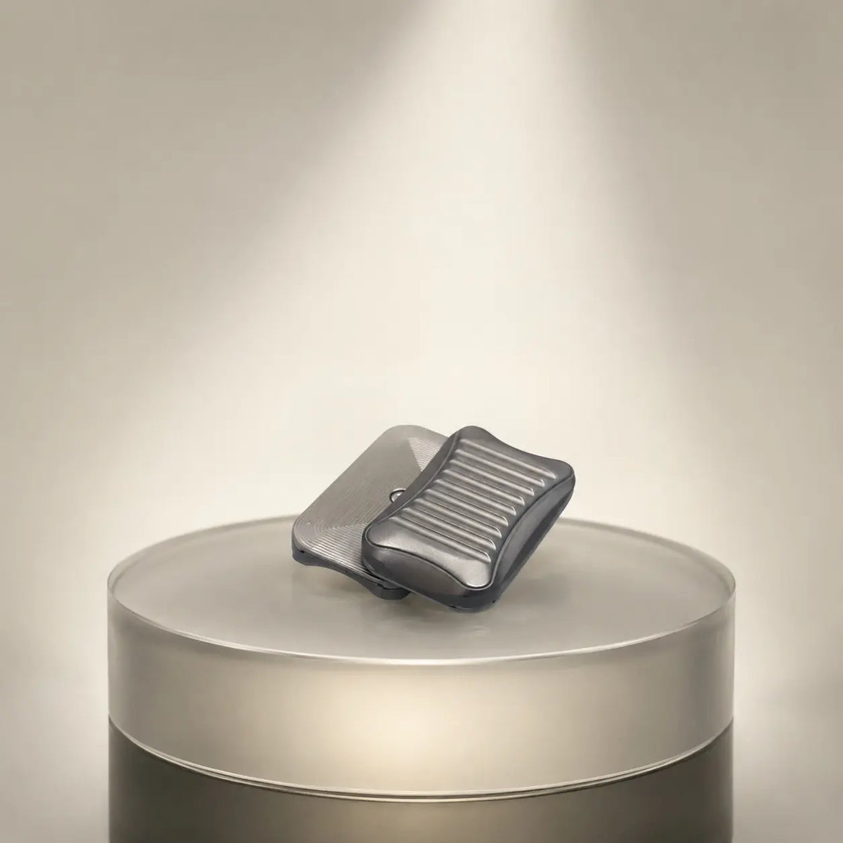 Stria magnetic fidget slider with offset plates on a round metallic display stand.