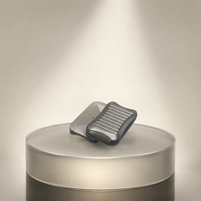 Stria magnetic fidget slider with offset plates on a round metallic display stand.