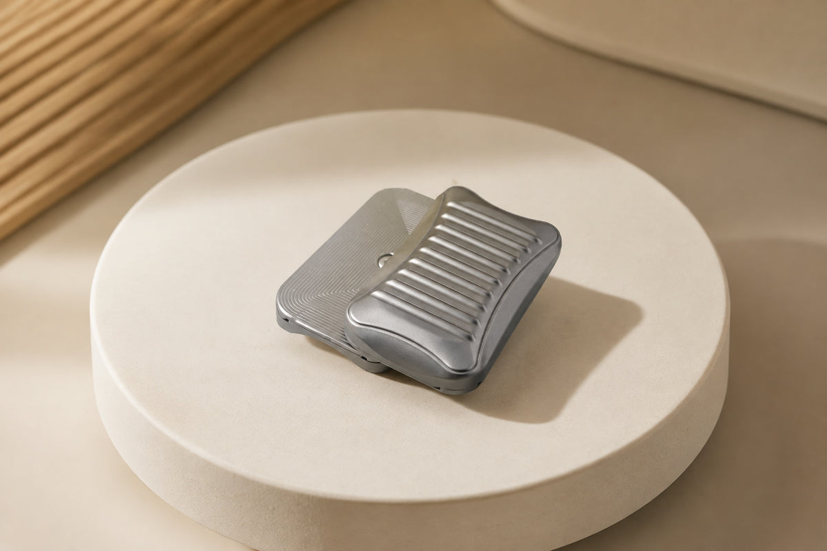Stria magnetic fidget slider with its grooved plate offset over a finely lined plate on a round stand.